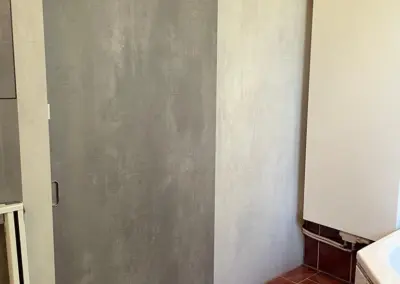 Artern: Elektrisch betriebene Schiebetür auf der Wand laufend. Die Tür wurde optisch an das Bad angepasst.